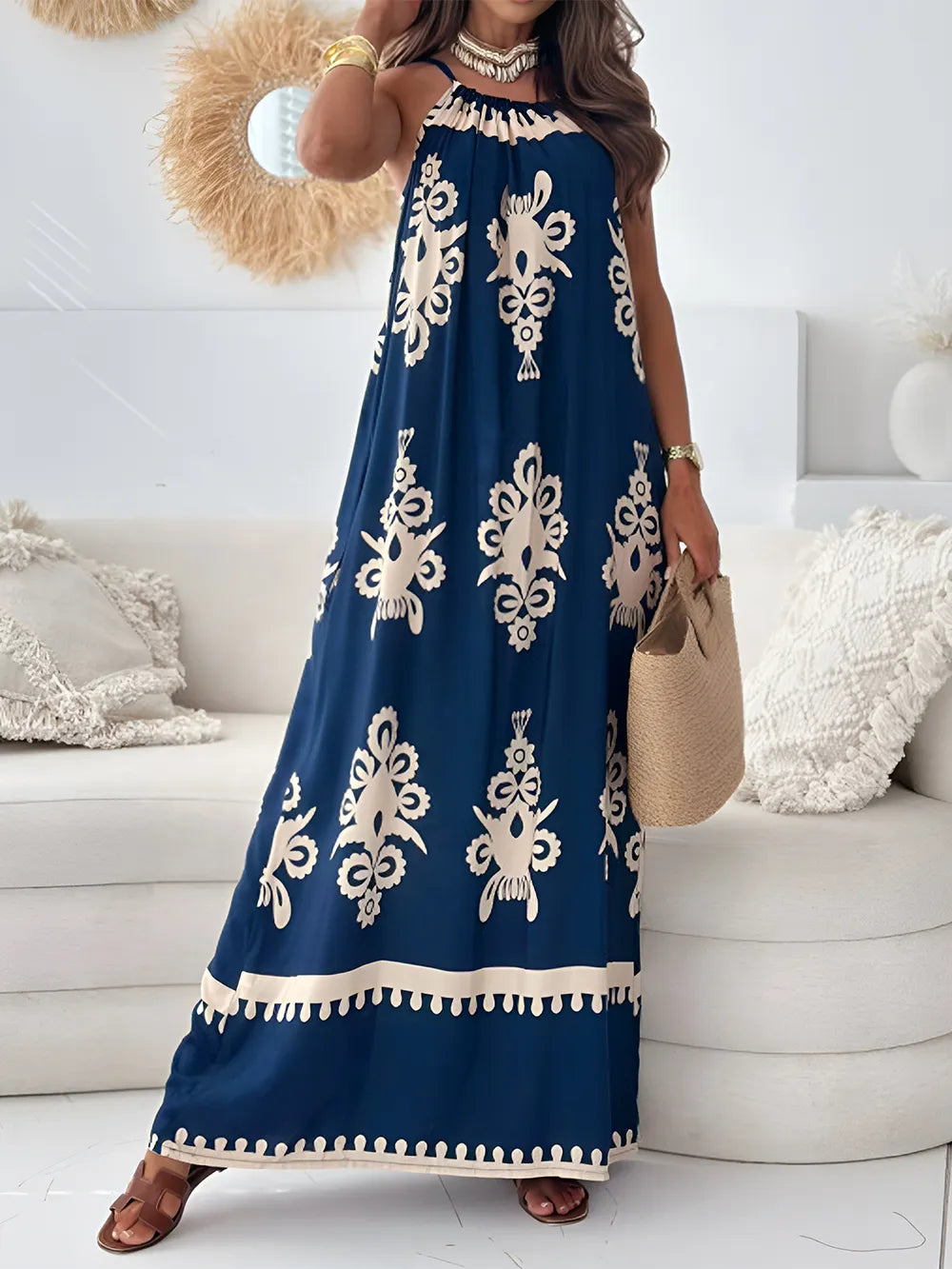 A woman wearing a white and black printed spaghetti strap sleeveless maxi dress with a sheer neckline.