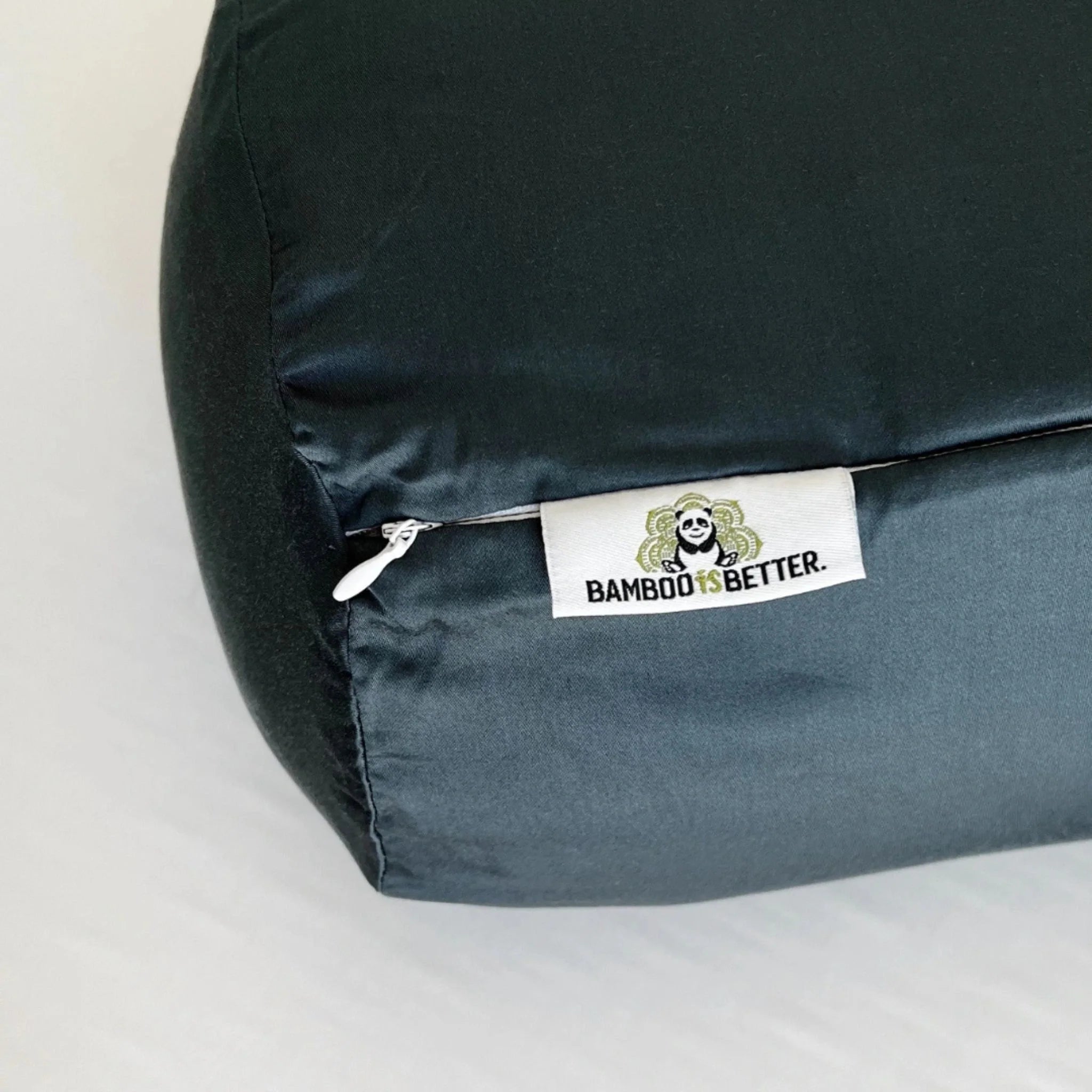 Dark green pillow with a 'Bamboo is Better' label on a light gray background