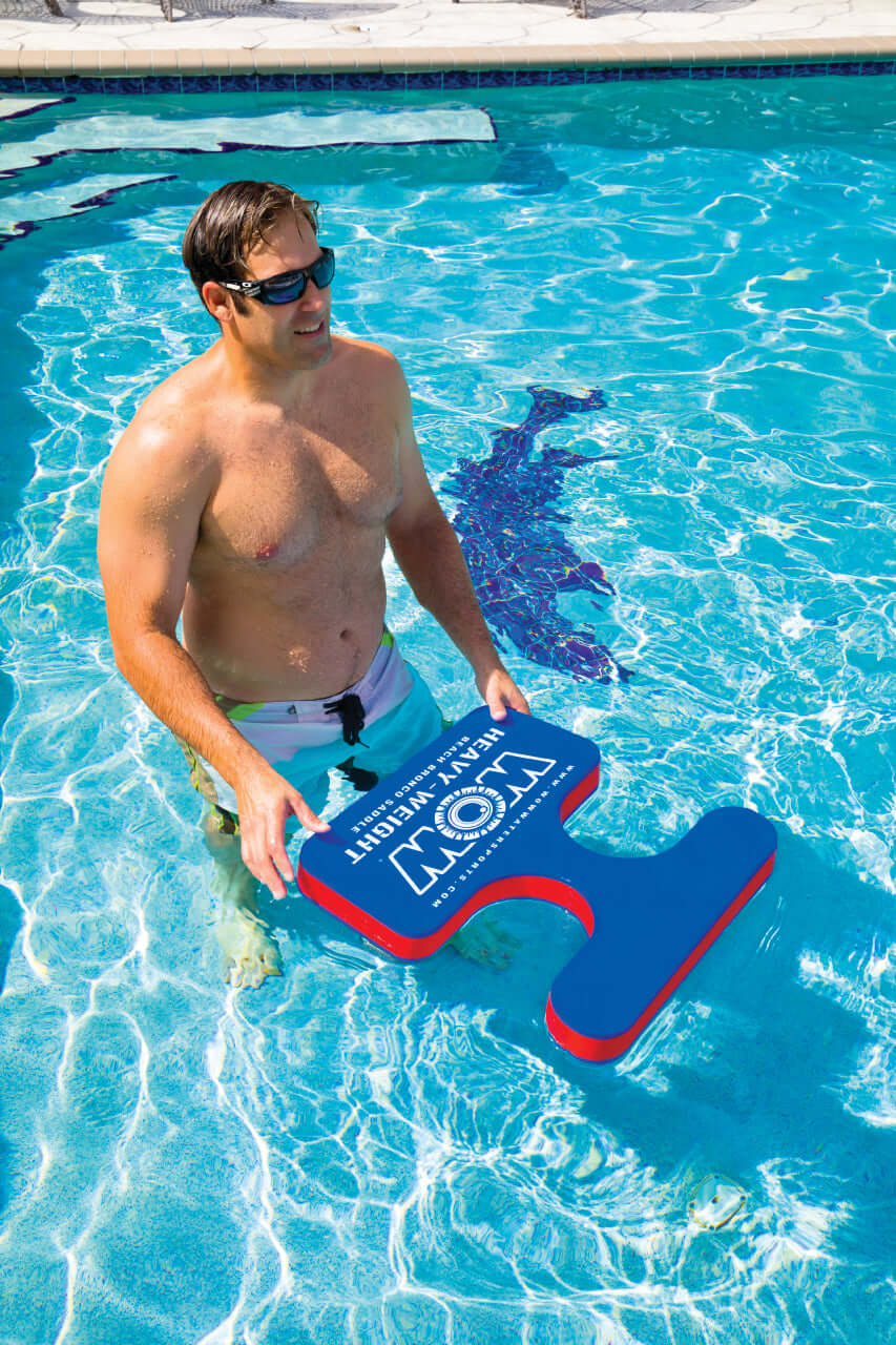 Man holding a blue and red swim board in a pool