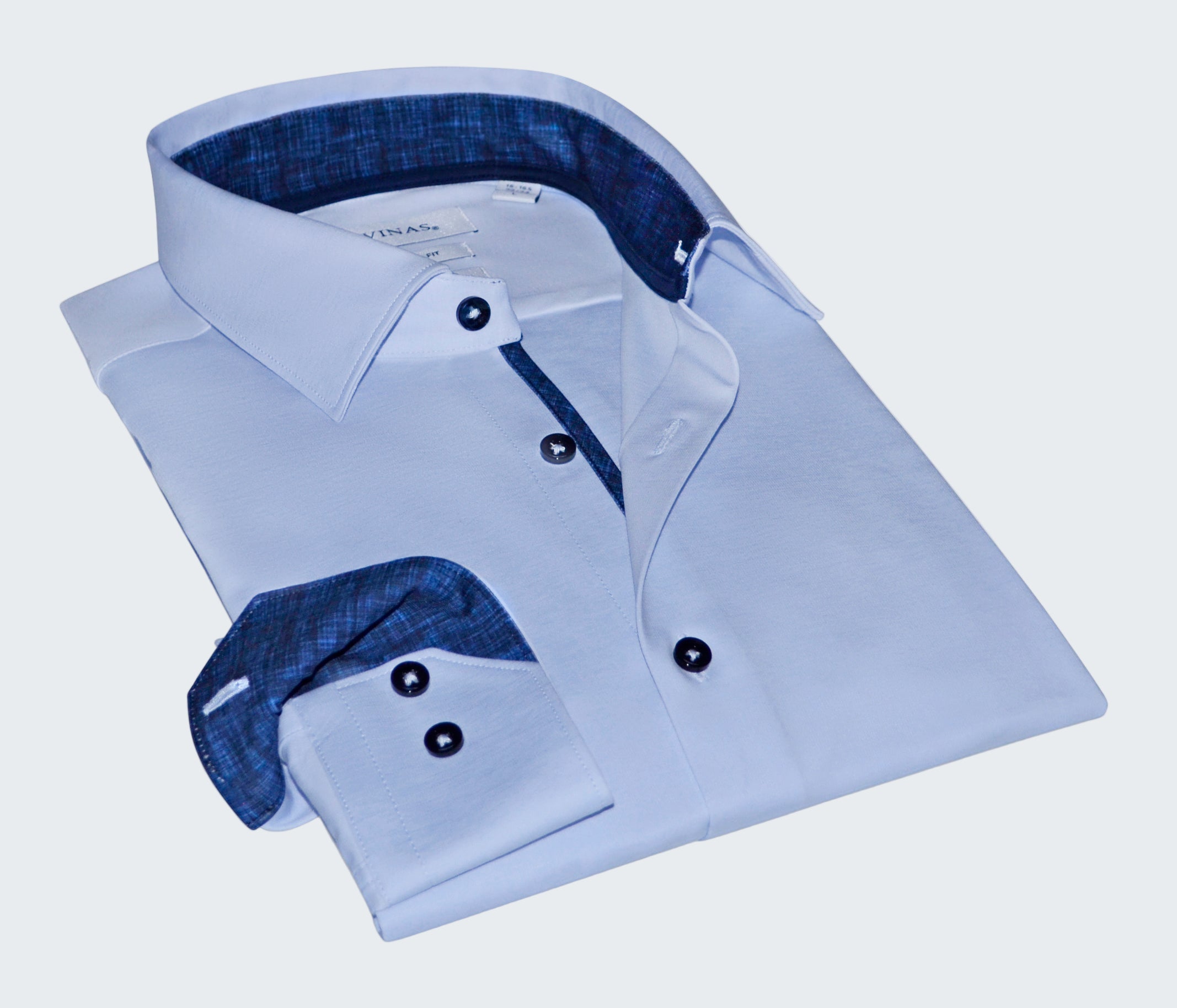 Folded light blue dress shirt with dark blue interior on a white background