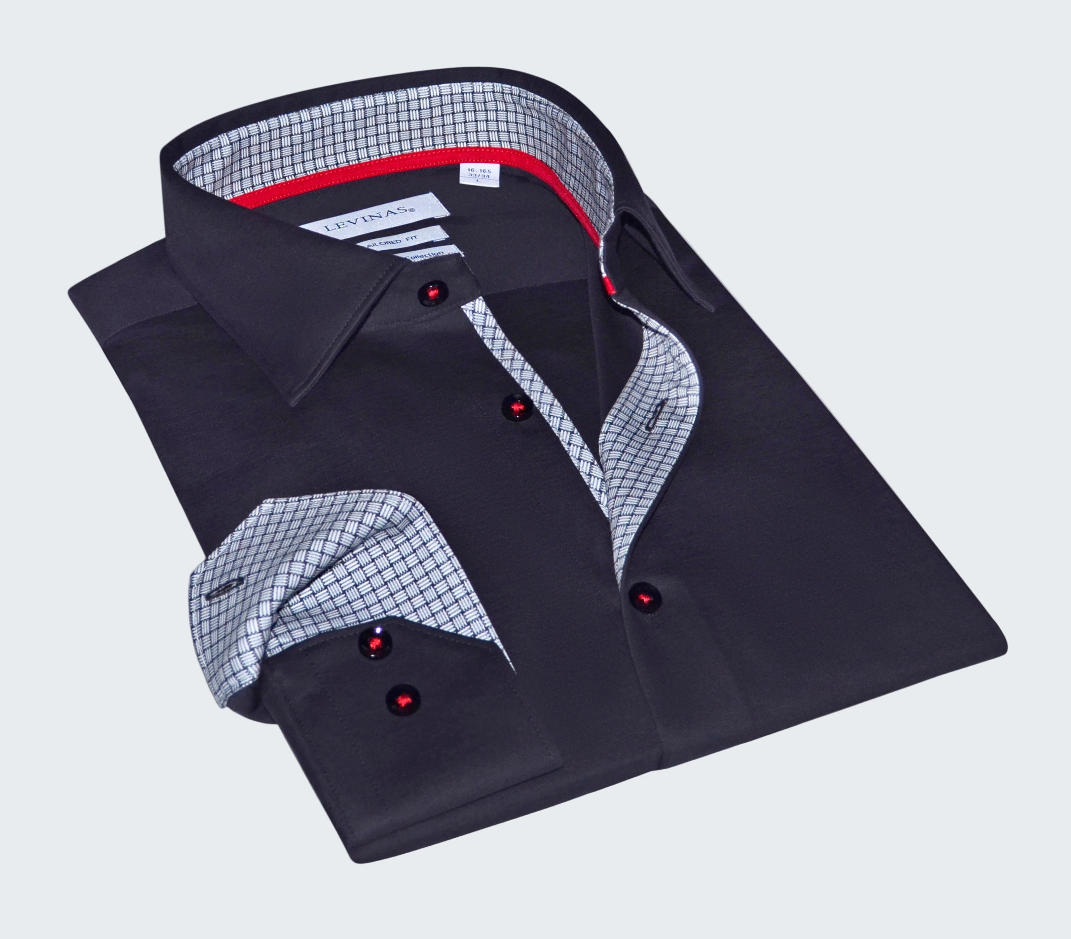 Folded black dress shirt with red buttons on a white background