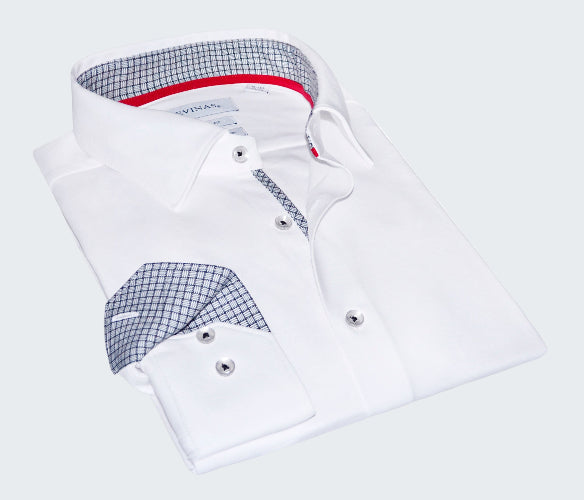 Folded white dress shirt with patterned inner lining on a white background