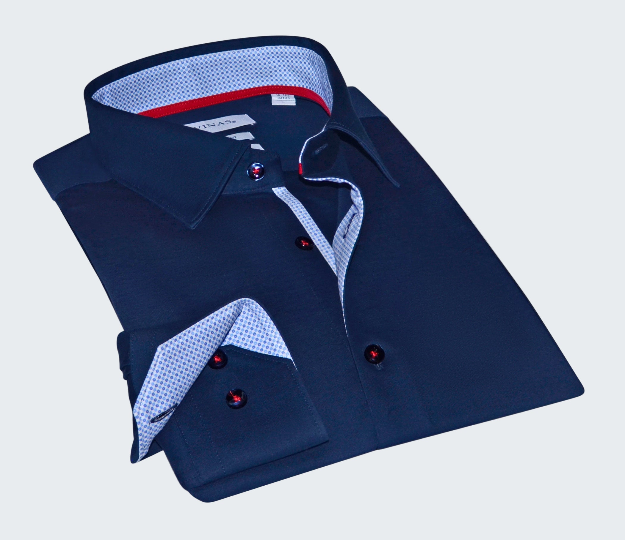 Folded navy blue dress shirt with patterned trim on a white background