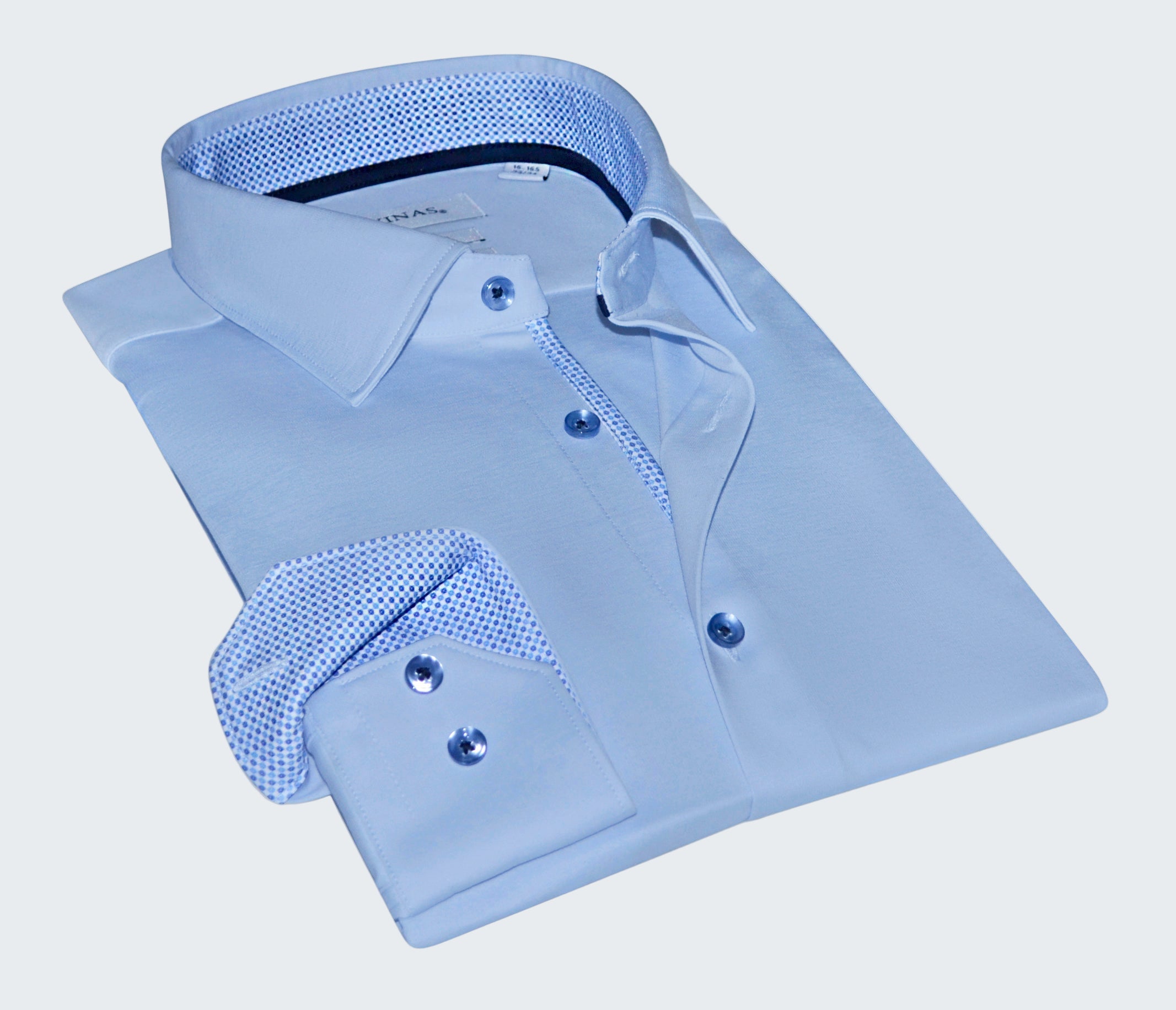 Folded light blue dress shirt with textured collar and cuffs on a white background
