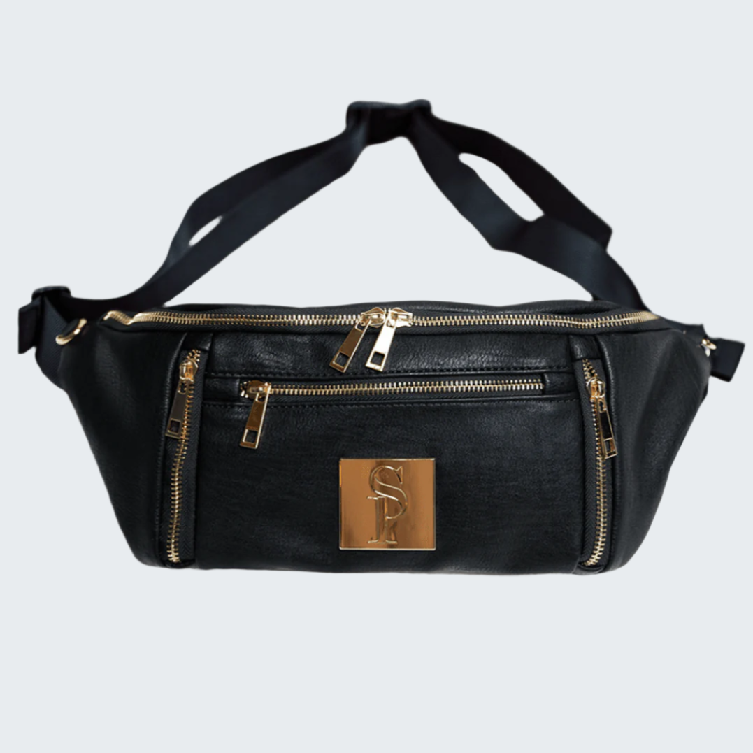 Black waist bag with gold zippers and logo on a wooden floor