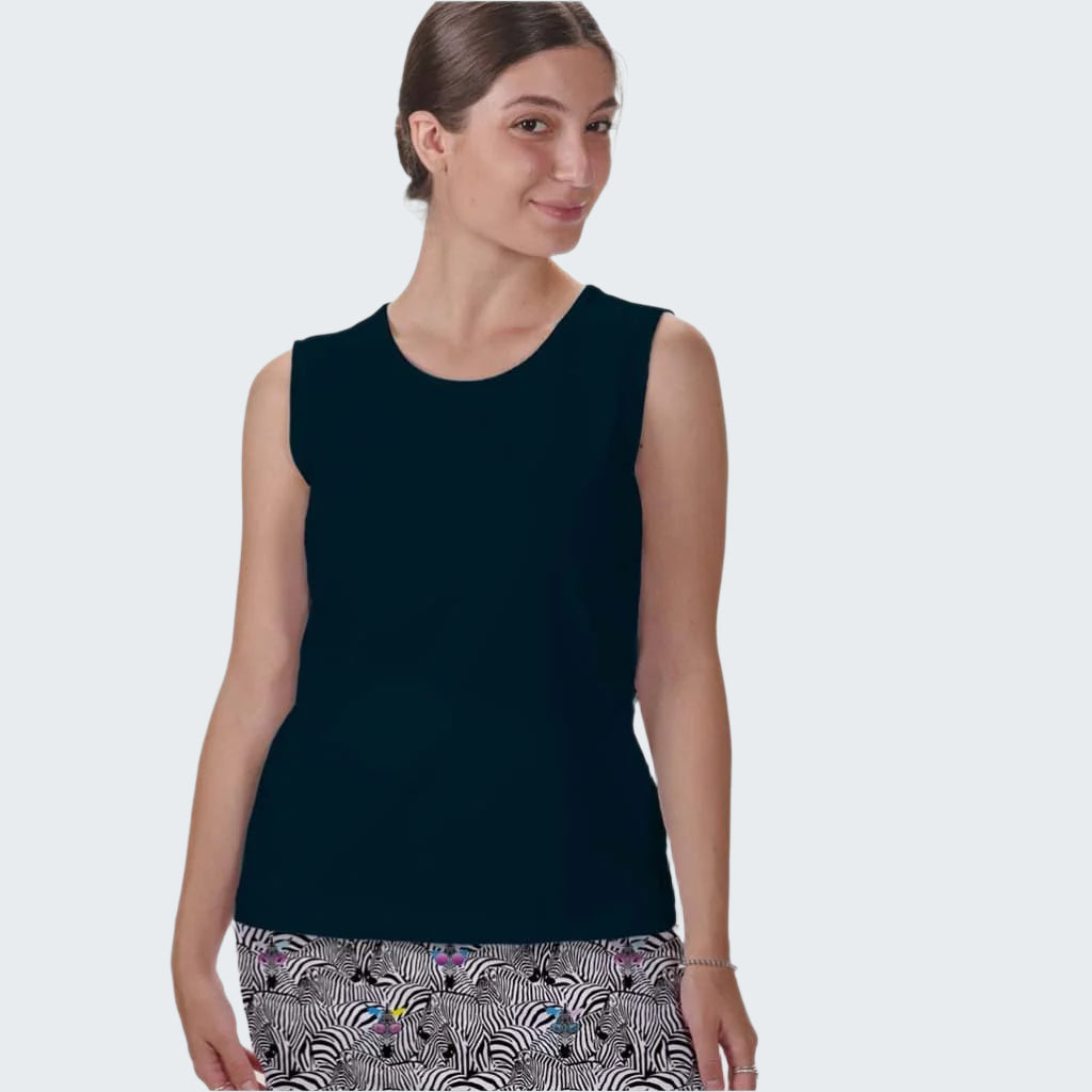 Woman wearing a dark blue sleeveless top with patterned pants on a white background