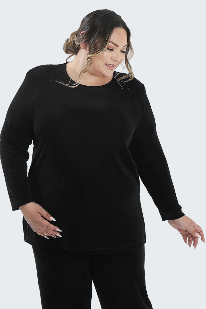 Woman wearing a black long-sleeve top and black pants on a white background