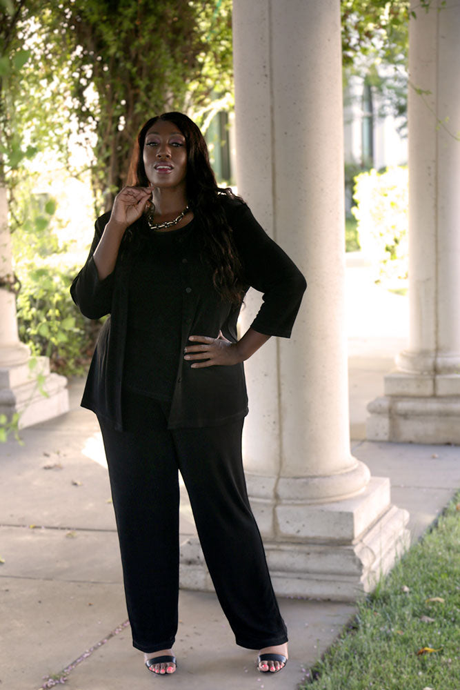 Woman in black outfit standing outdoors near classical architecture