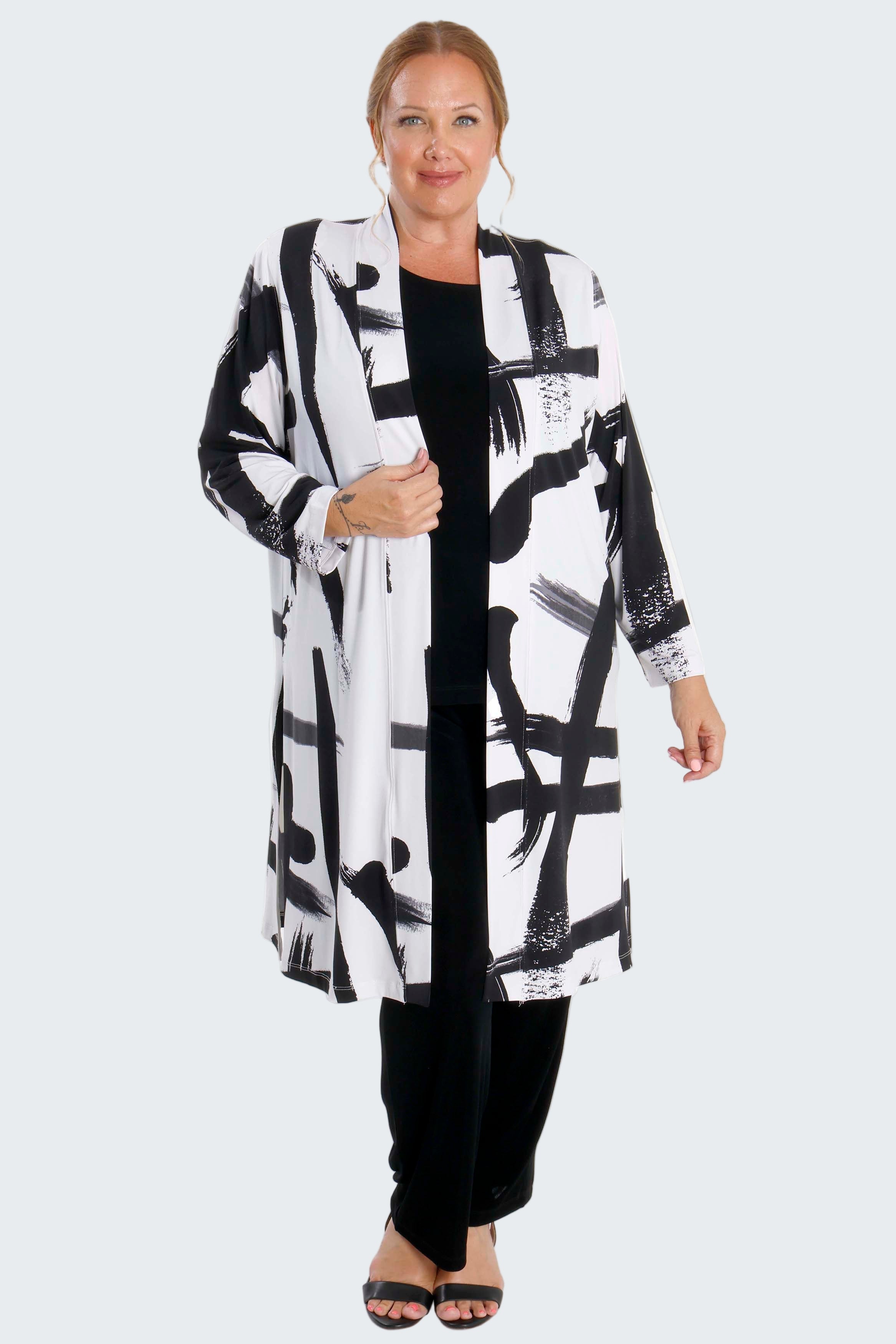 Woman wearing a black and white abstract patterned coat on a white background