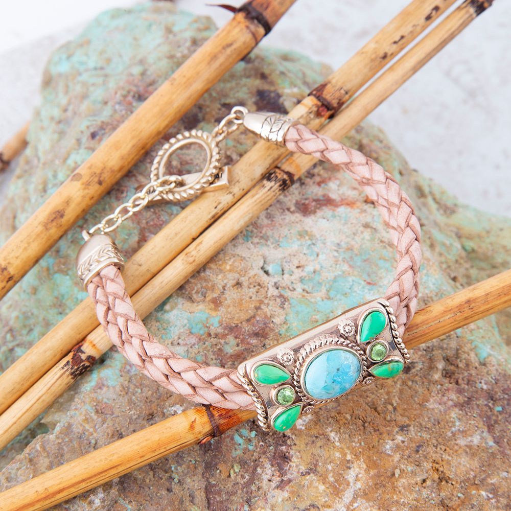 Bracelet with braided design and turquoise and green stone accents on a natural background