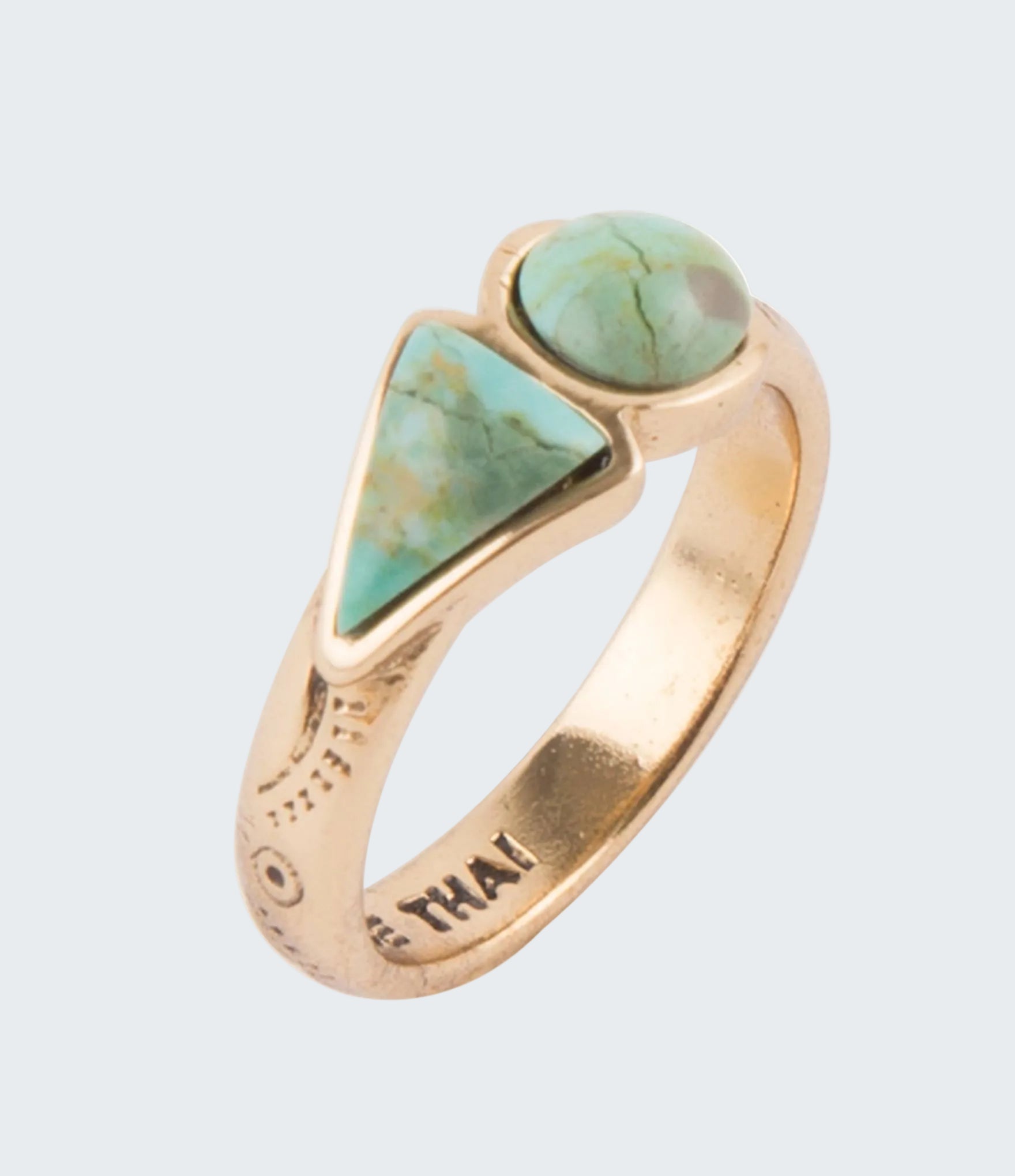 Gold ring with turquoise stones on a white background