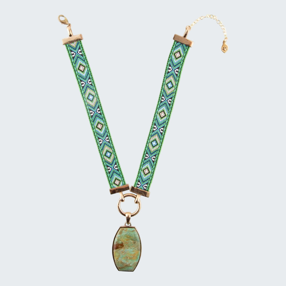 Green patterned strap with gold accents and a turquoise stone on a white background