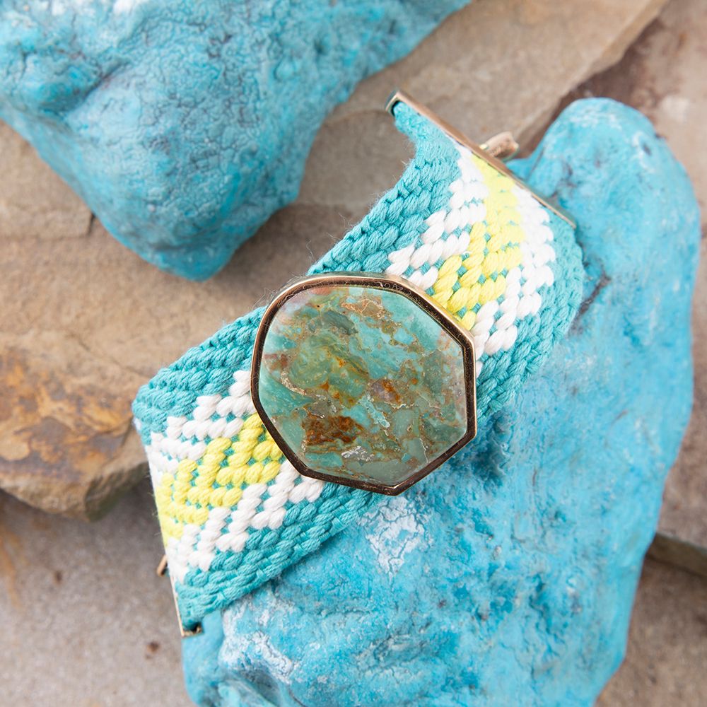 Jewelry with a stone-like center on a textured blue surface