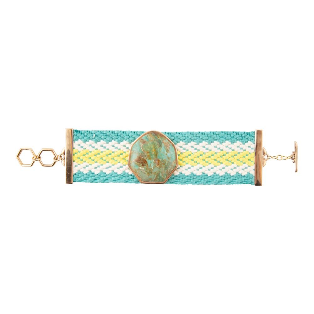 Bracelet with turquoise stone and gold accents on a white background