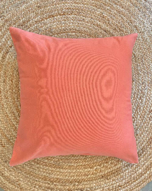 Coral pillow on a woven mat