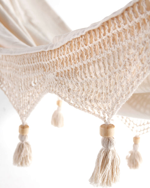 Beige woven fabric with tassels on a white background