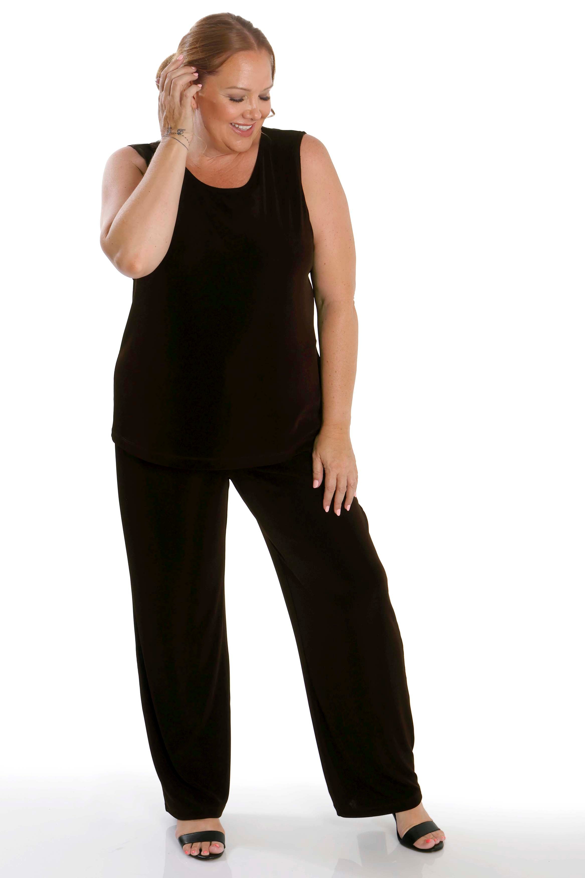 Woman wearing a black sleeveless top and pants on a white background