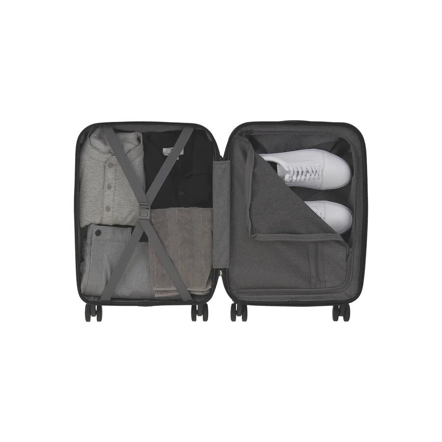 Open suitcase with clothes and shoes on a white background
