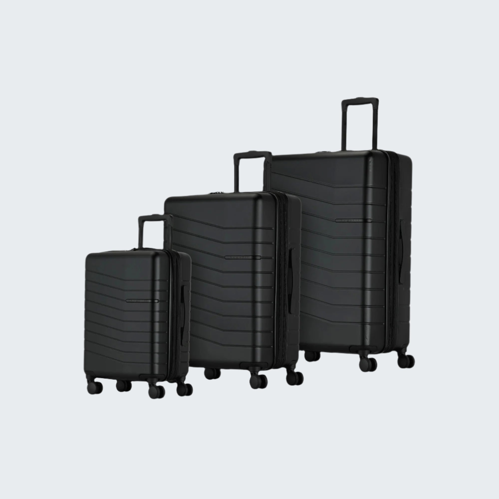 Set of three black suitcases of different sizes on a white background