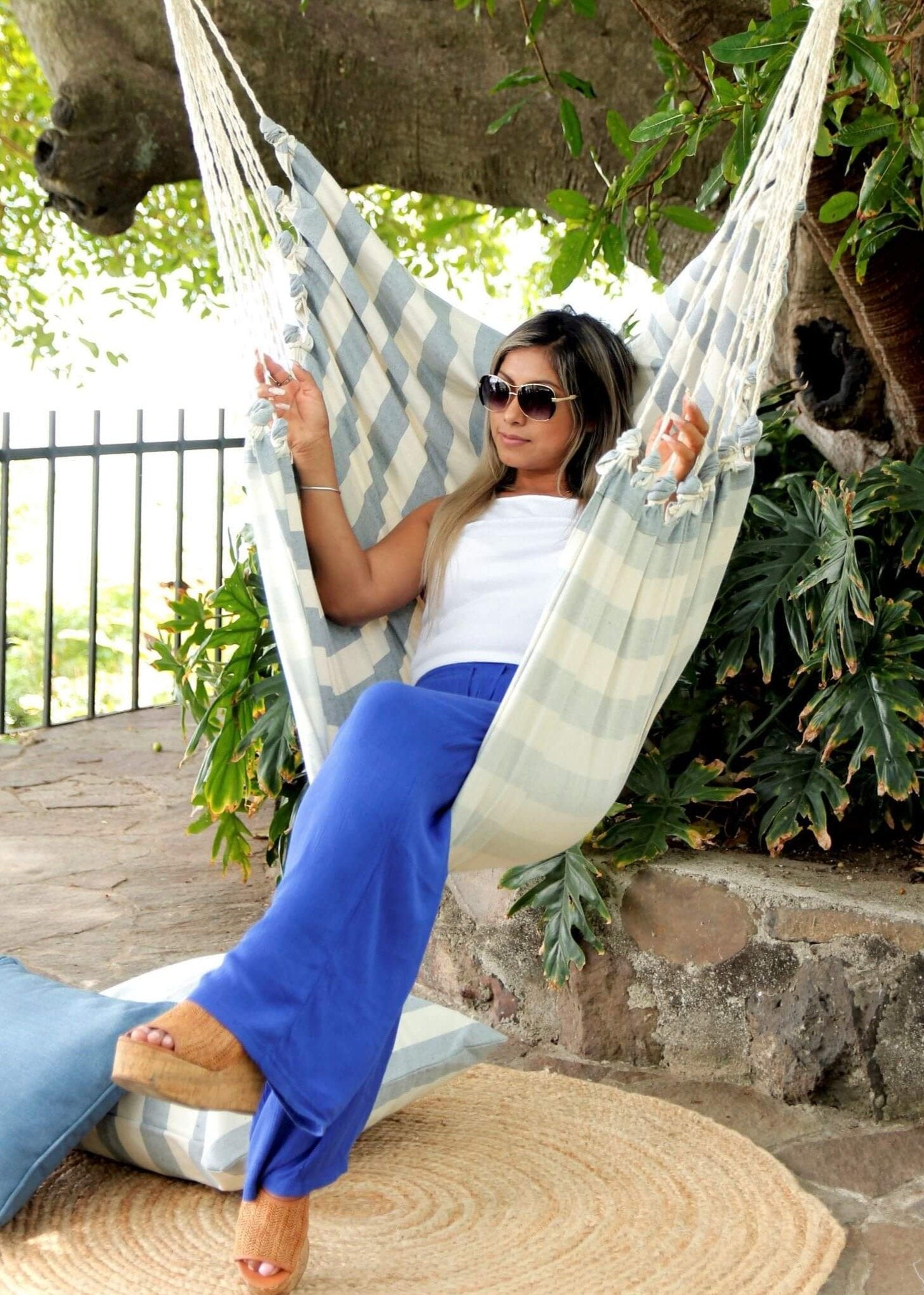 Woman relaxing in a hammock surrounded by greenery