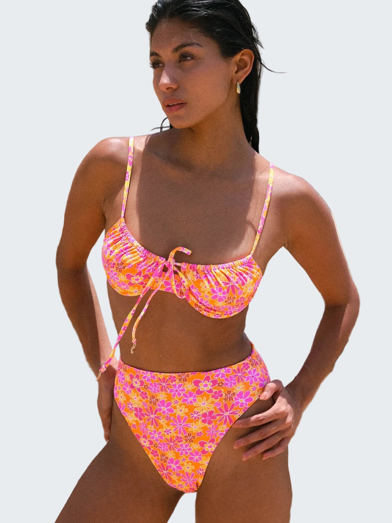 Woman wearing a colorful bikini set against a rocky background