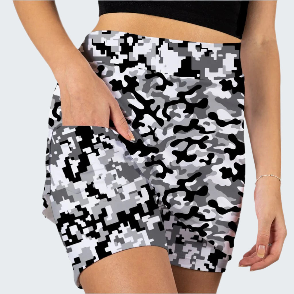 Person wearing a black, white, and gray camouflage patterned skirt on a white background
