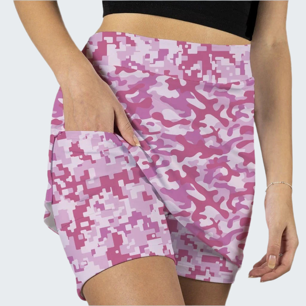 Pink camouflage skirt worn by a person on a white background