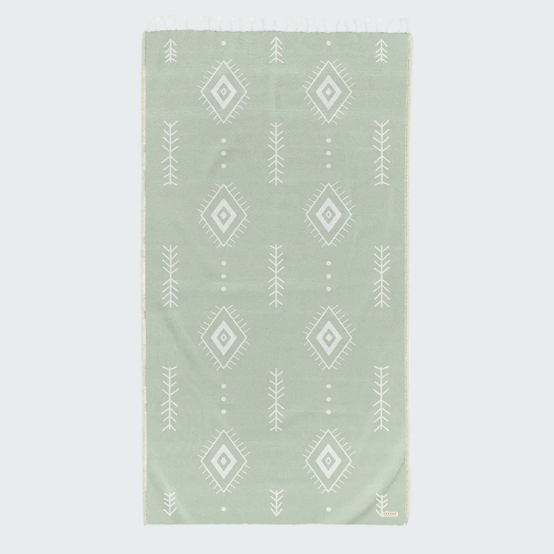 Green towel with white geometric pattern on a white background