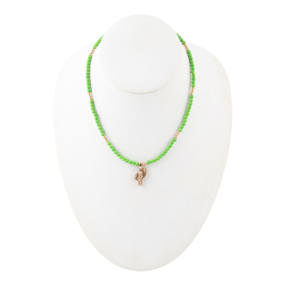 Green beaded necklace with a small gold charm on a white mannequin bust.