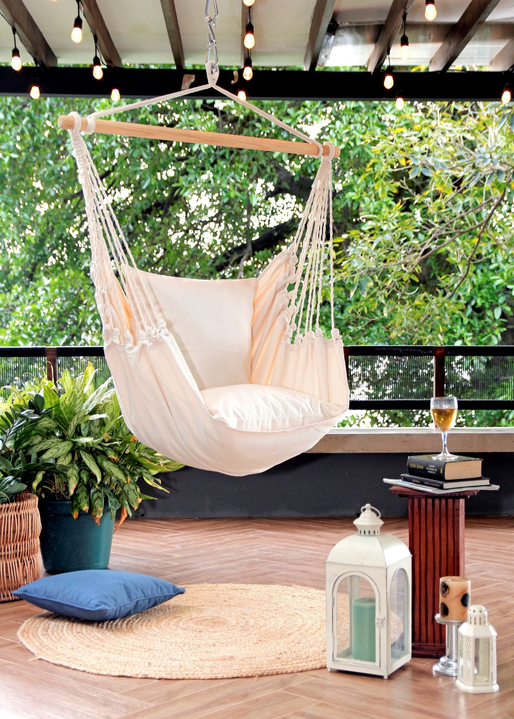 Hanging chair in a cozy outdoor setting with plants and a table.