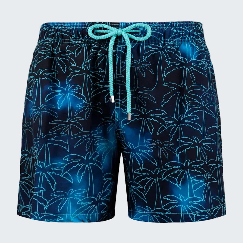 Blue swim shorts with palm tree pattern on a white background
