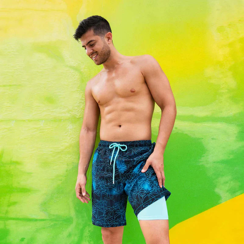 Man wearing blue swim shorts with a green and yellow background