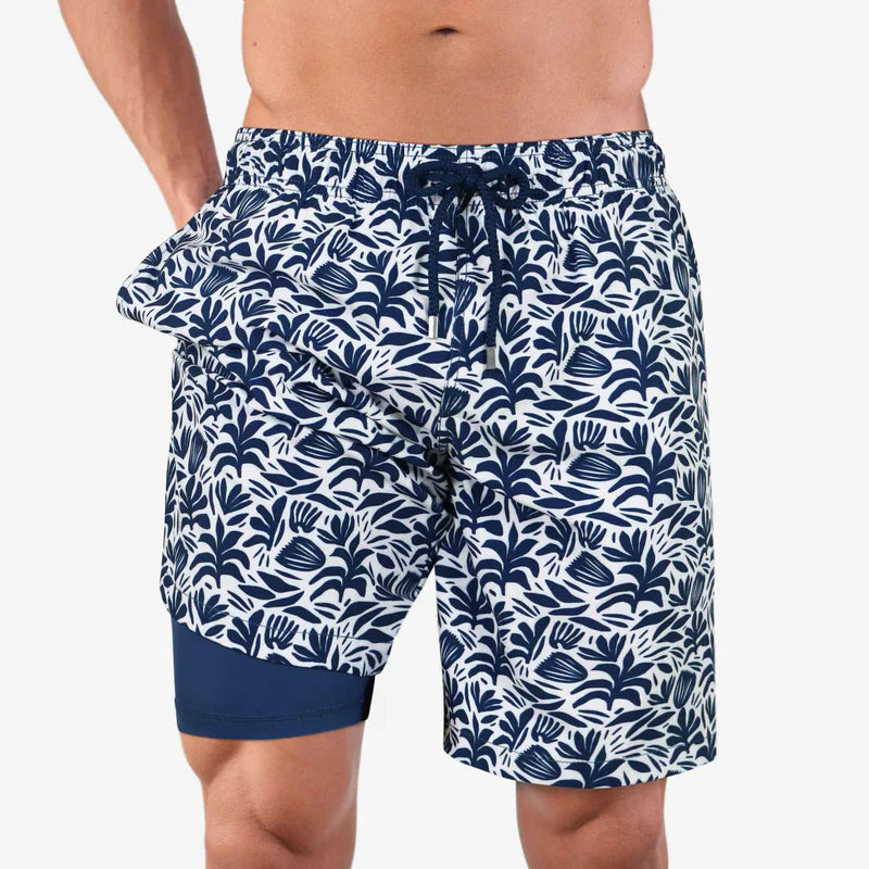 Navy blue and white patterned swim shorts on a plain background