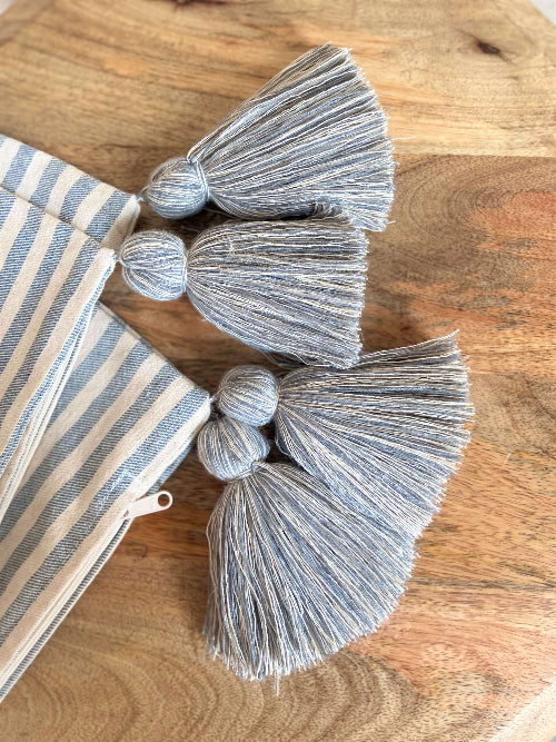 Striped fabric with gray tassels on a wooden surface
