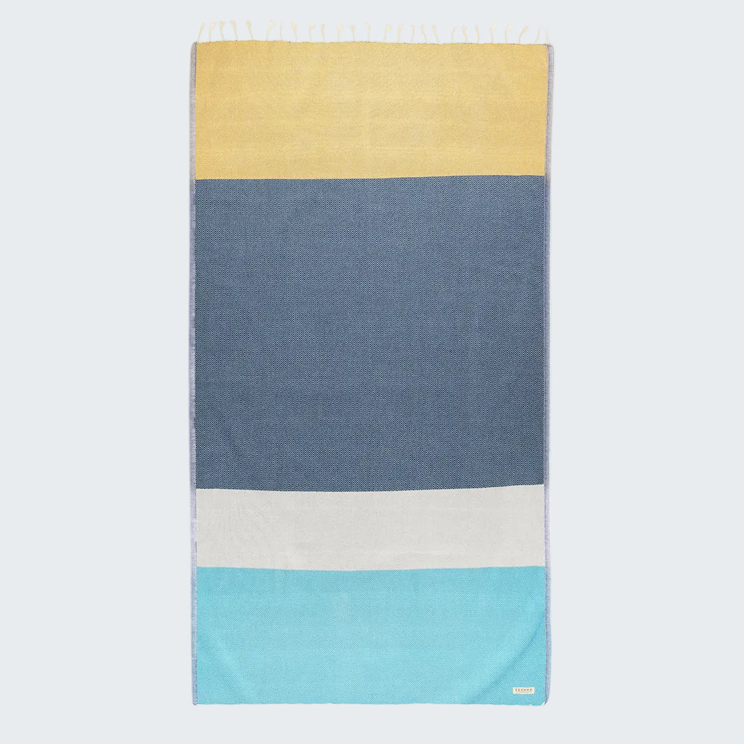 Color-blocked towel with yellow, blue, white, and turquoise stripes on a white background