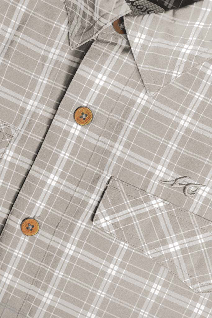 Close-up of a plaid shirt with buttons and a brand logo.