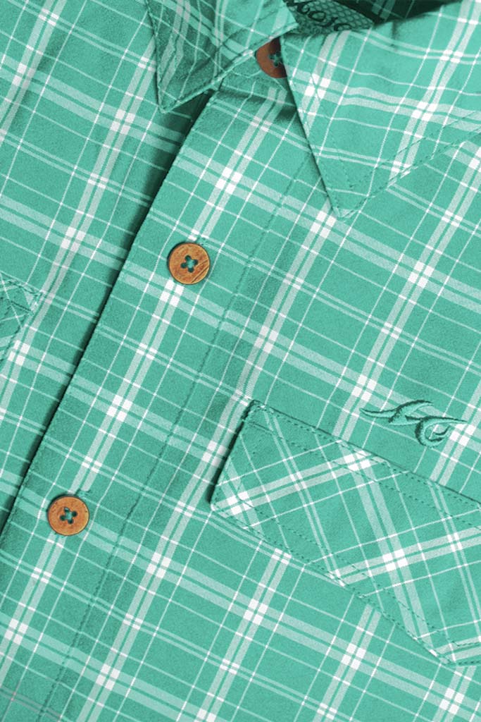 Close-up of a green plaid shirt with buttons and a brand logo.