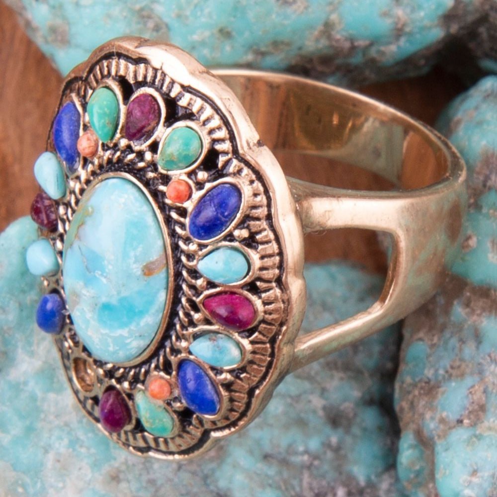 Decorative ring with colorful gemstones on a textured turquoise background