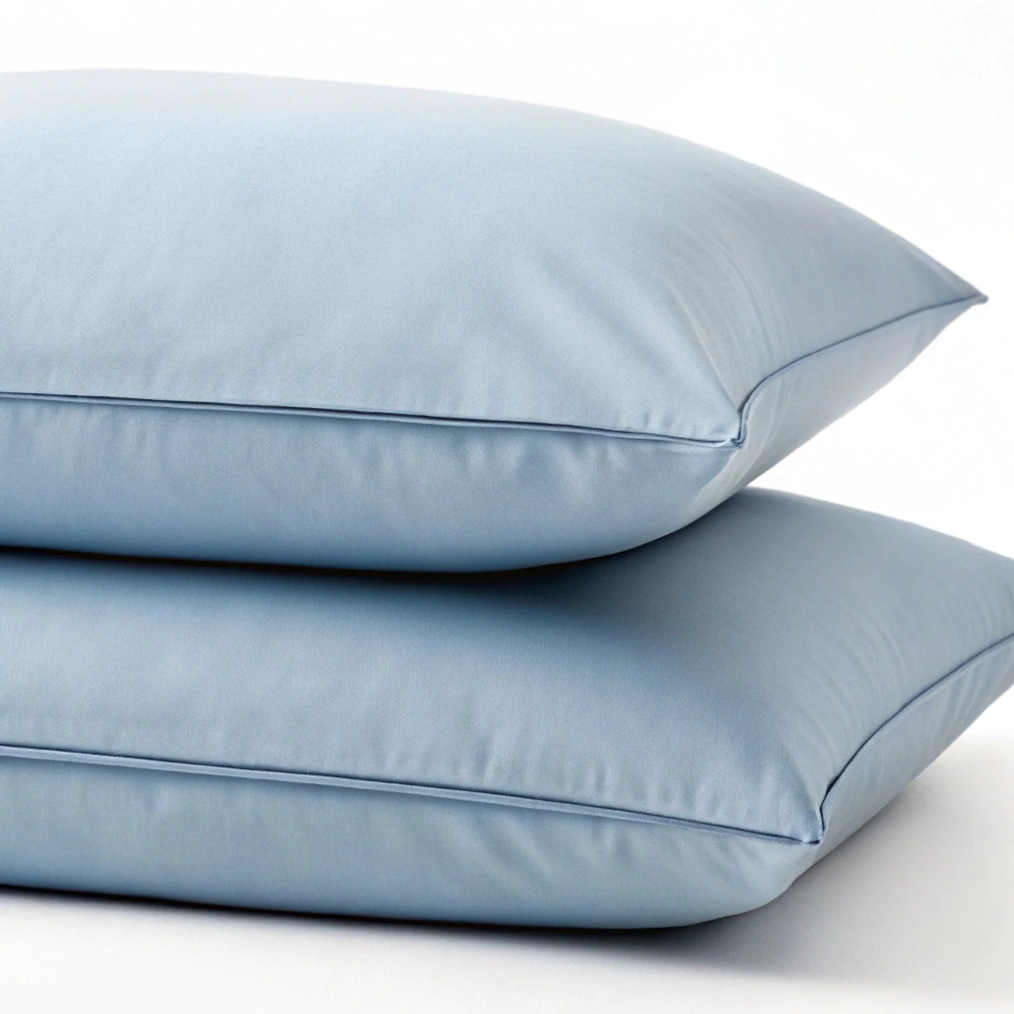 Two light blue pillows stacked on a white background