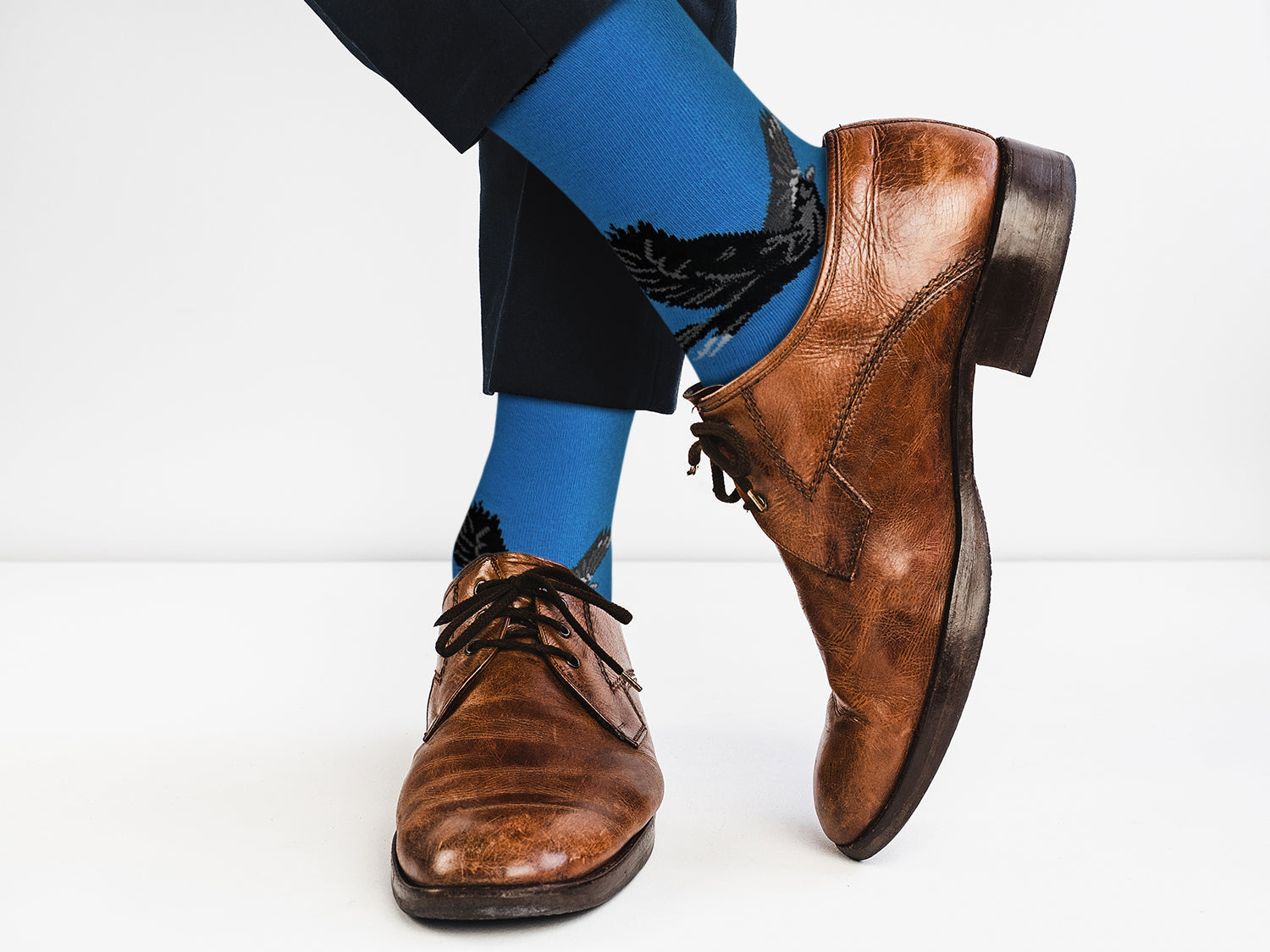 Brown dress shoes and blue socks on a white background