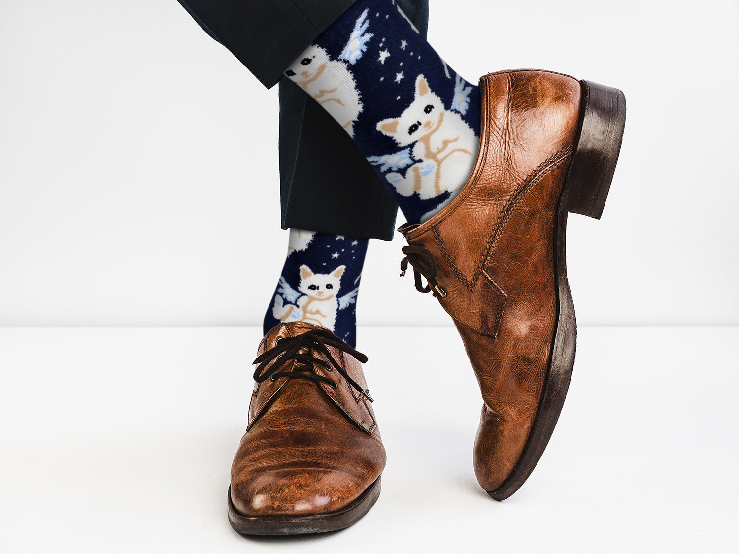 Brown dress shoes with blue socks featuring white dog illustrations on a white background