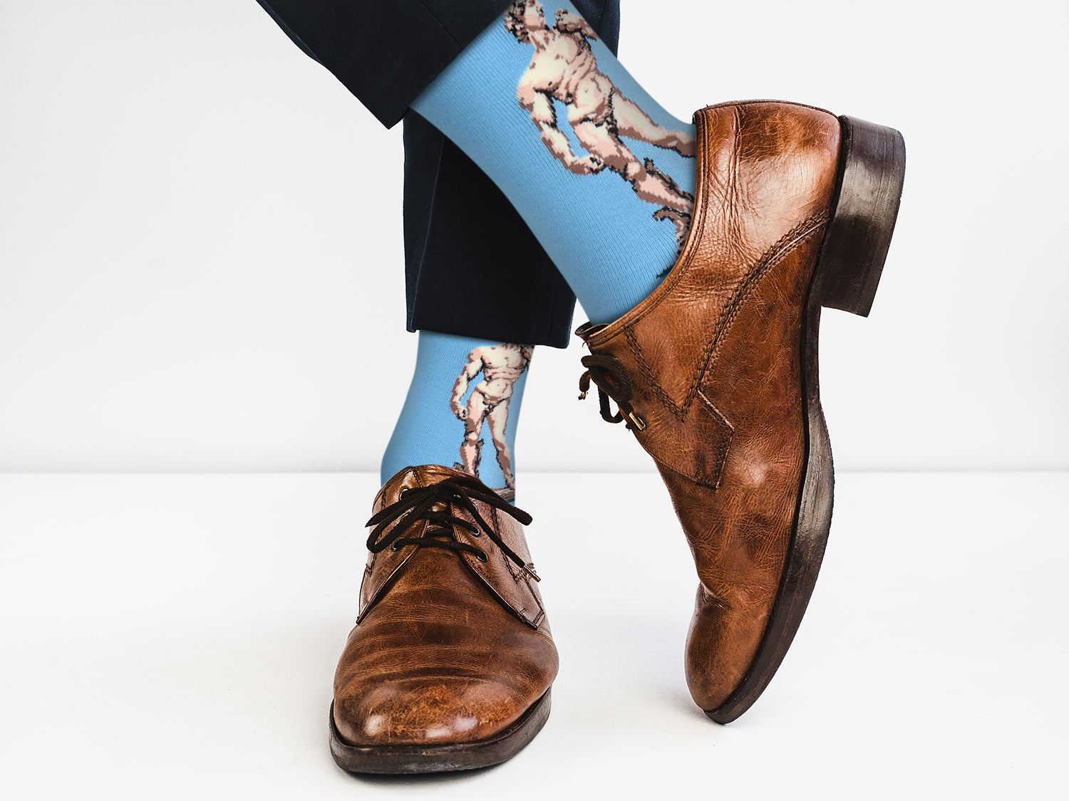 Brown leather shoes with blue socks featuring classical art design on a white background