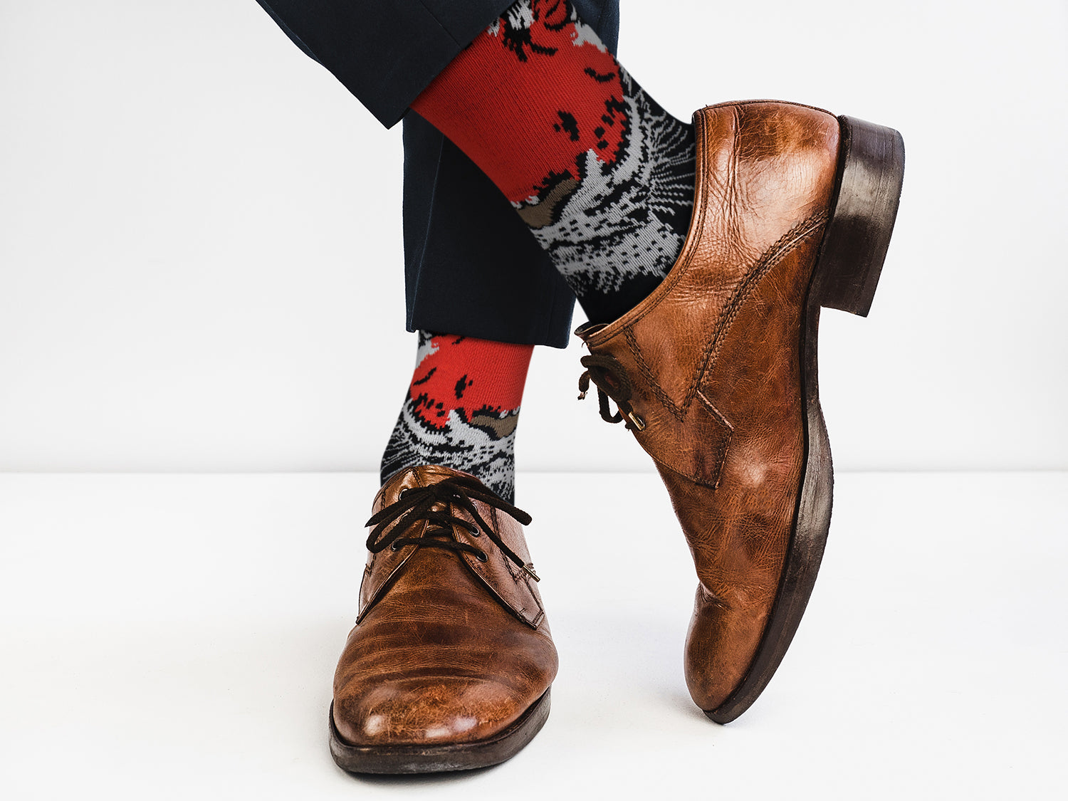 Brown leather shoes and patterned socks on a white background