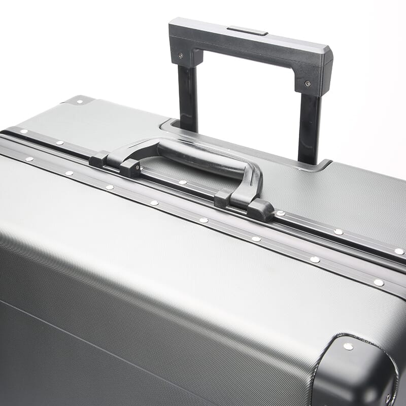 Close-up of a silver suitcase with handle and wheels on a white background