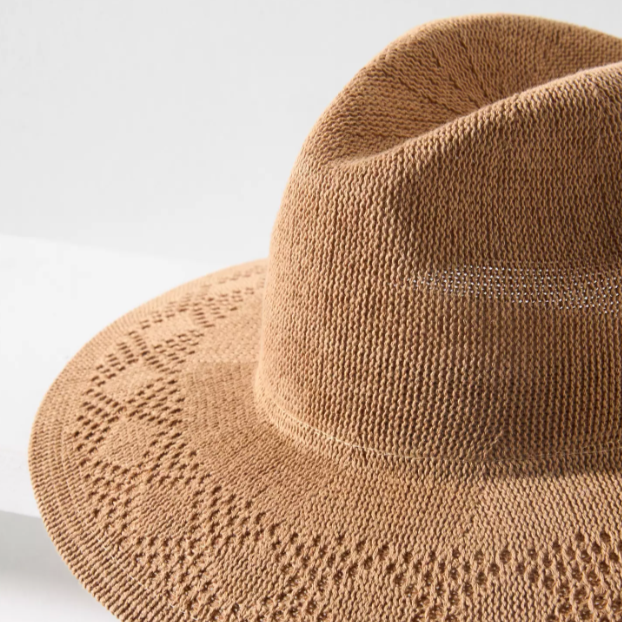 Brown knitted hat on a light gray background