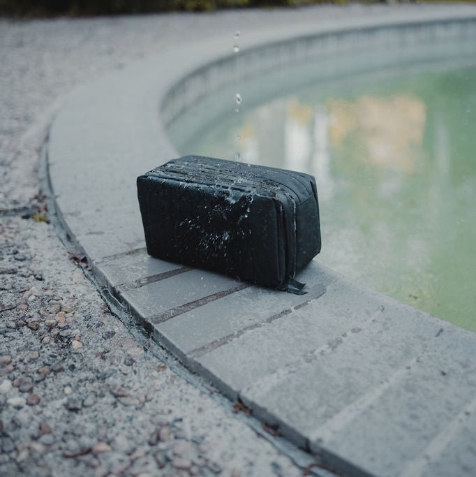 Black rectangular pool泄水器 on a concrete edge by a pool