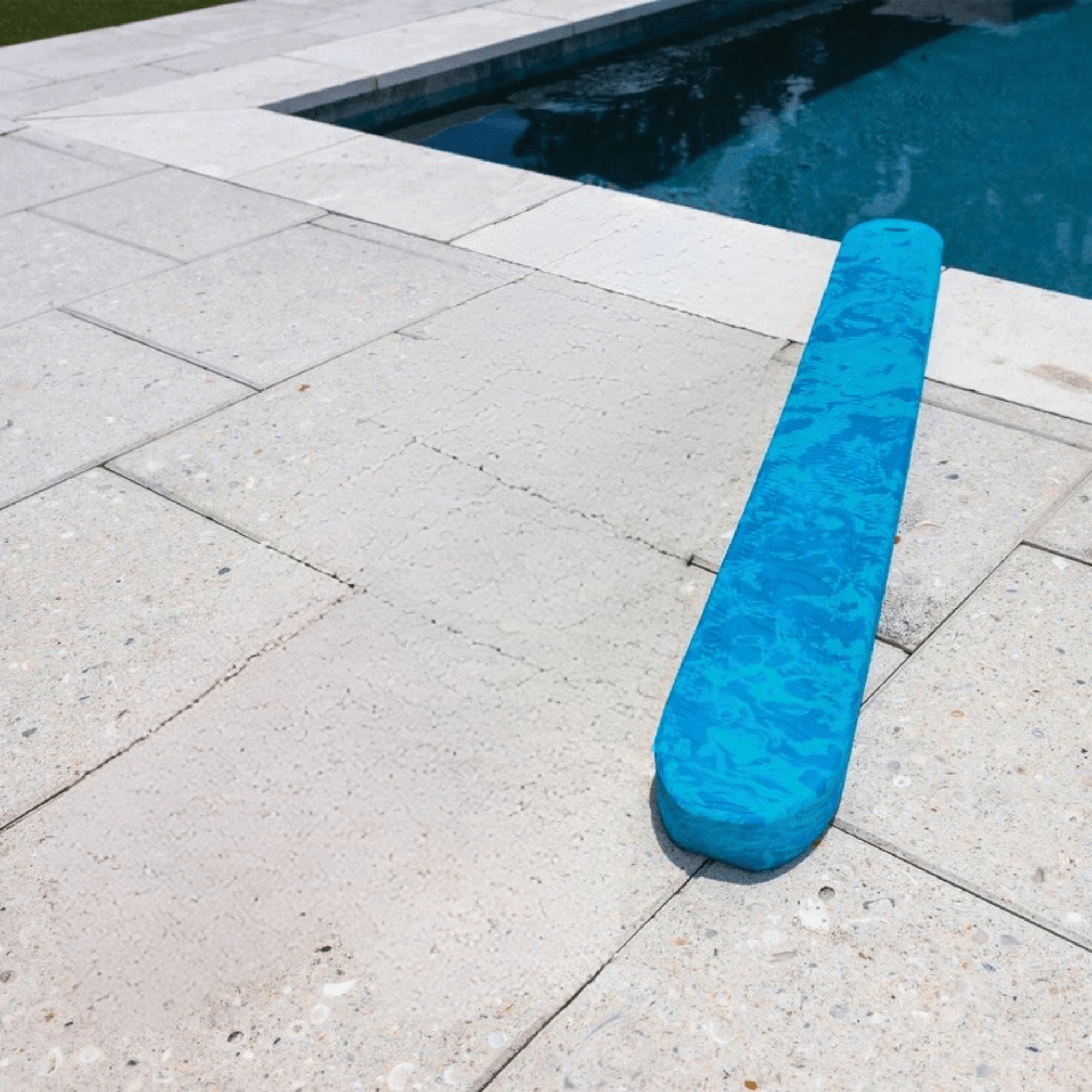 Blue pool cover on a concrete surface next to a pool.