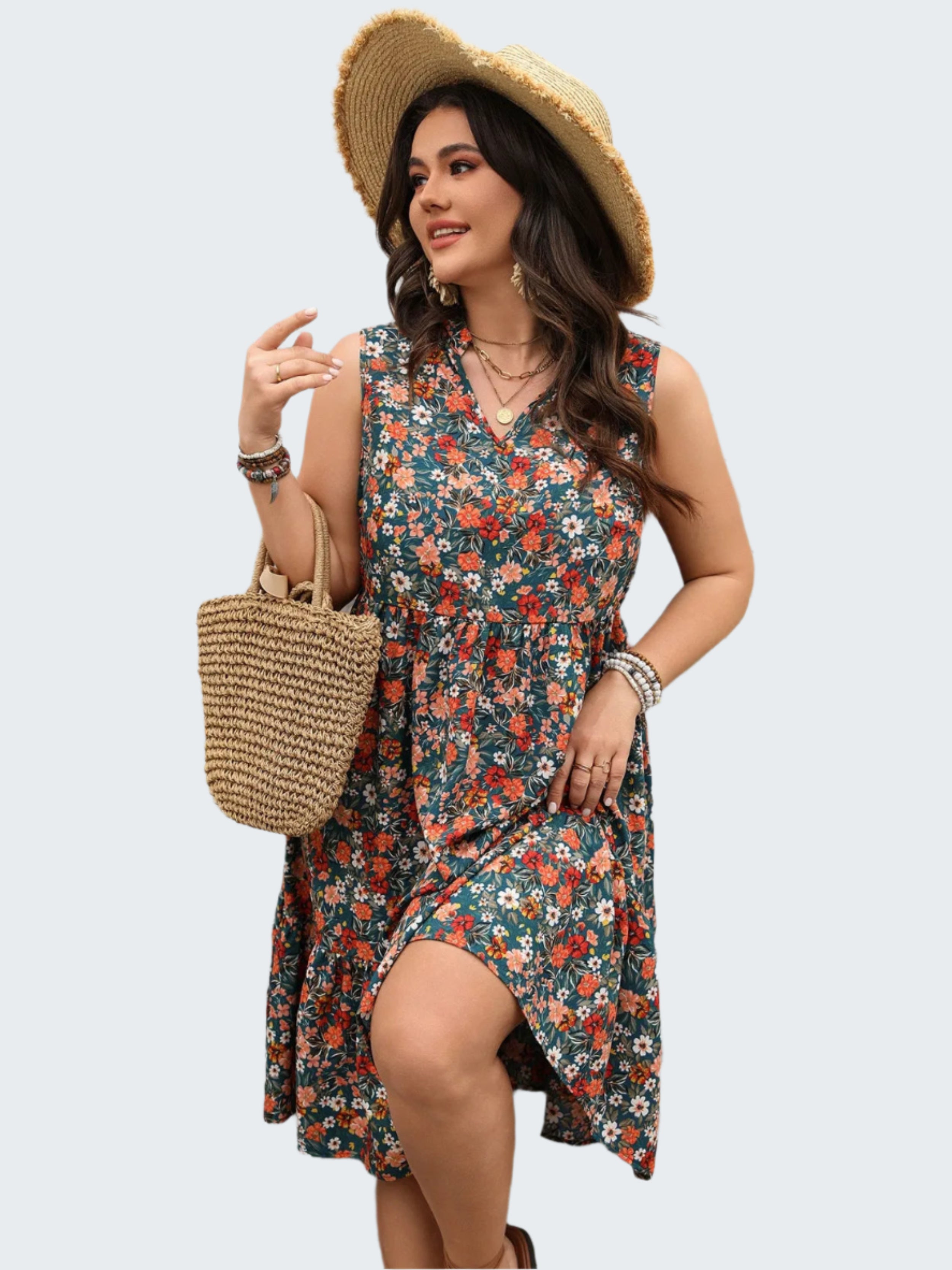 A woman wearing a floral sleeveless dress with a notched neckline, tiered skirt, and straw hat holding a wicker tote bag.
