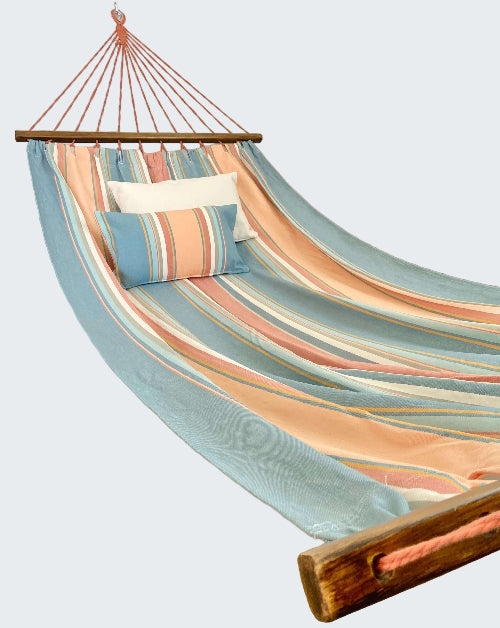 Colorful striped hammock with pillows in a room setting.