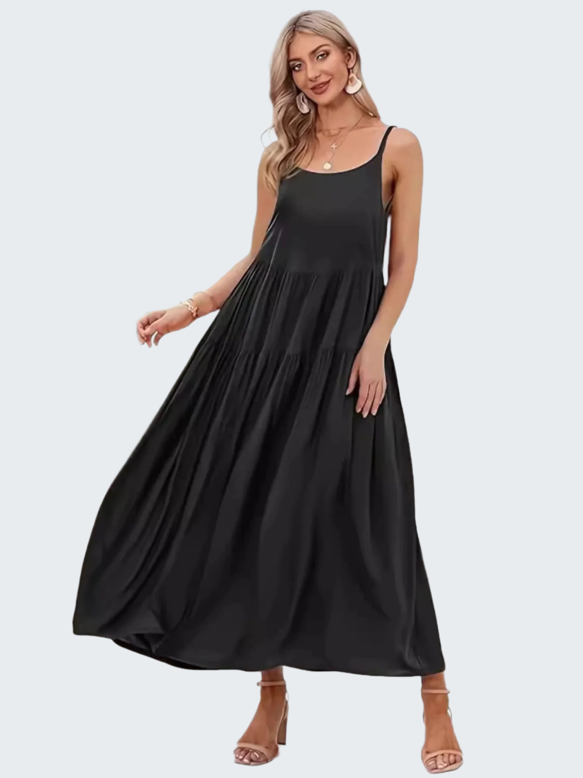 A model wearing a black sleeveless midi cami dress with a scoop neck.